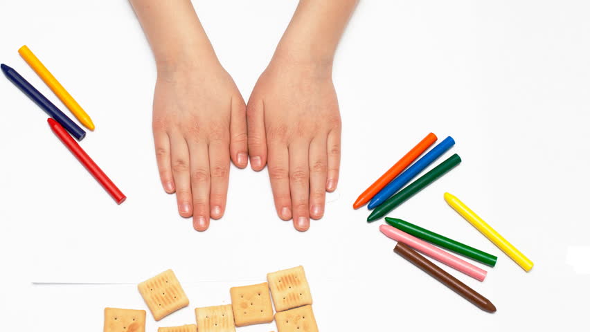 child draws a picture with crayons