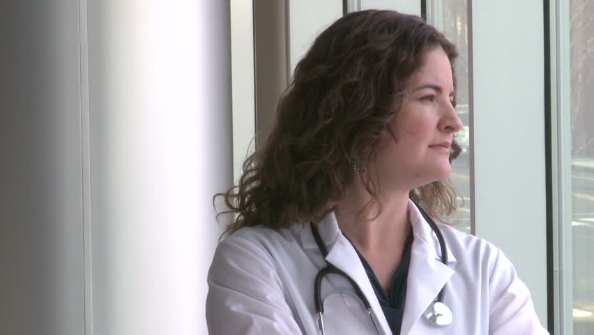 Female doctor turns to the camera and looks confident (1 of 2)