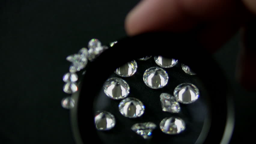 Diamond Inspection Close Up (HD). Large Round cut diamonds inspected by a jewelers loupe for flaws and quality.