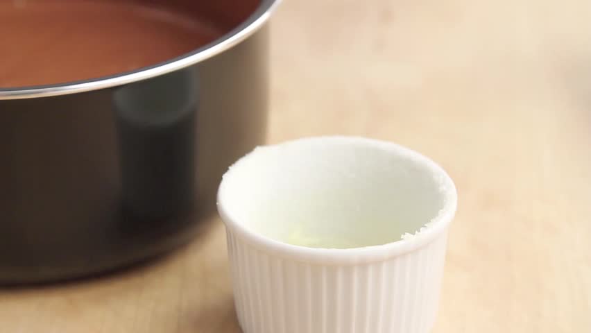 Chocolate souffle being poured into a prepared ramekin