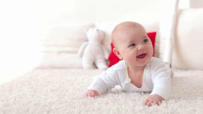 Baby lie on stomach and smiling. Dolly shot.