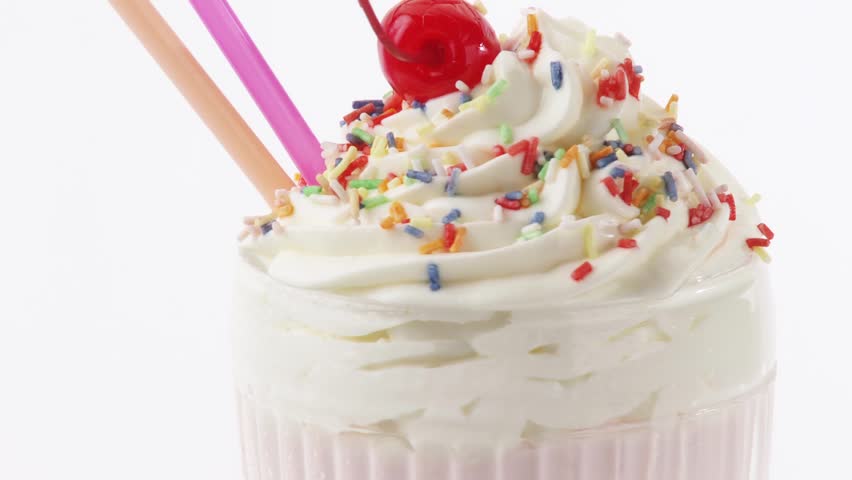 Milkshake with cream, sprinkles and cocktail cherry