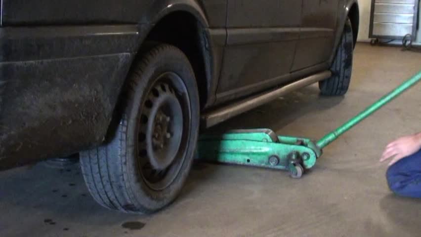 Auto mechanic in his workshop repairing tires