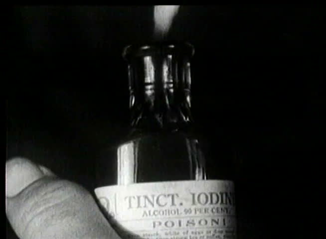 Close-up of hand dipping cotton swab into poison bottle