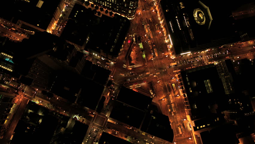 Aerial night vertical view of San Francisco city street traffic and illuminated skyscrapers, North America, USA