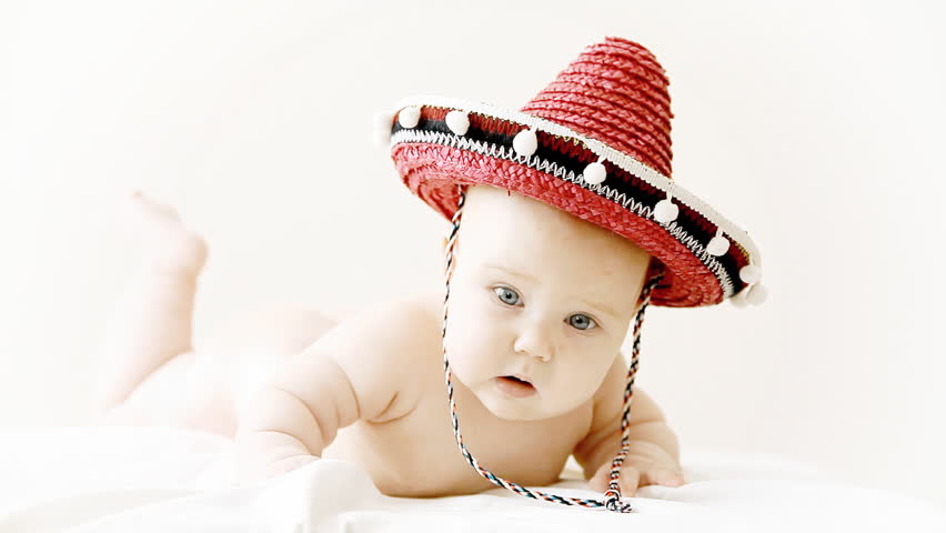 Baby in sombrero hat with maracas on the light background
