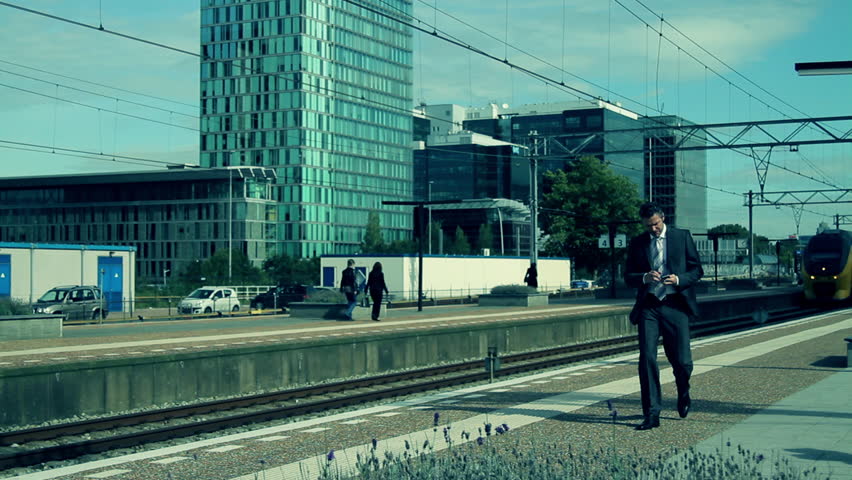 Business male answering phone at train station