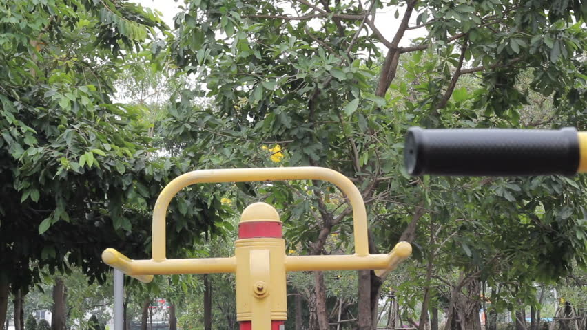 A young man begins working out on the exercise equipment at a local park.