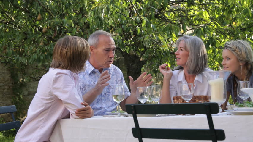 Father telling story to family at dinner table