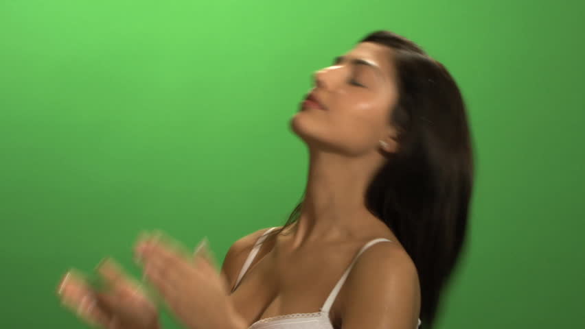 MEDIUM SHOT OF A YOUNG WOMAN APPLYING MOISTURIZER ON GREEN SCREEN