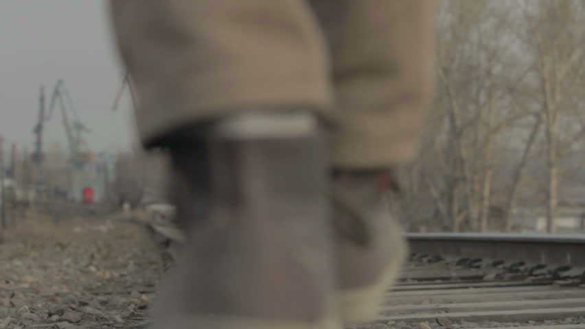 Young man goes to rail against backdrop of the city