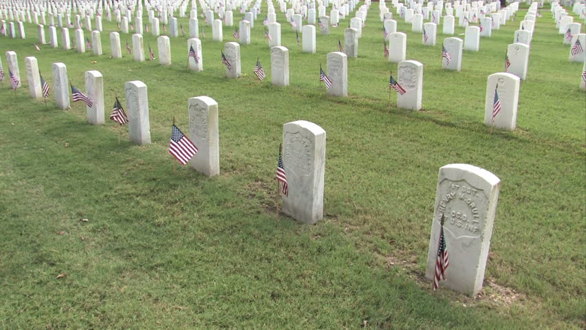 Graves and headstones at Ft Sam Houston Veterans Cemetery San Antonio Texas. Headstones and flags. Heroes and warriors, members of military and veterans. Zoom in and tilt.