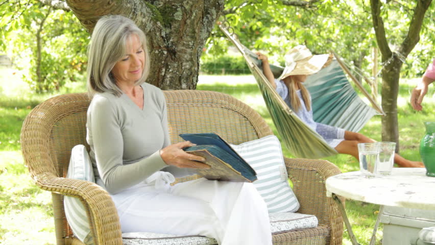 Parents in garden going through family photo album