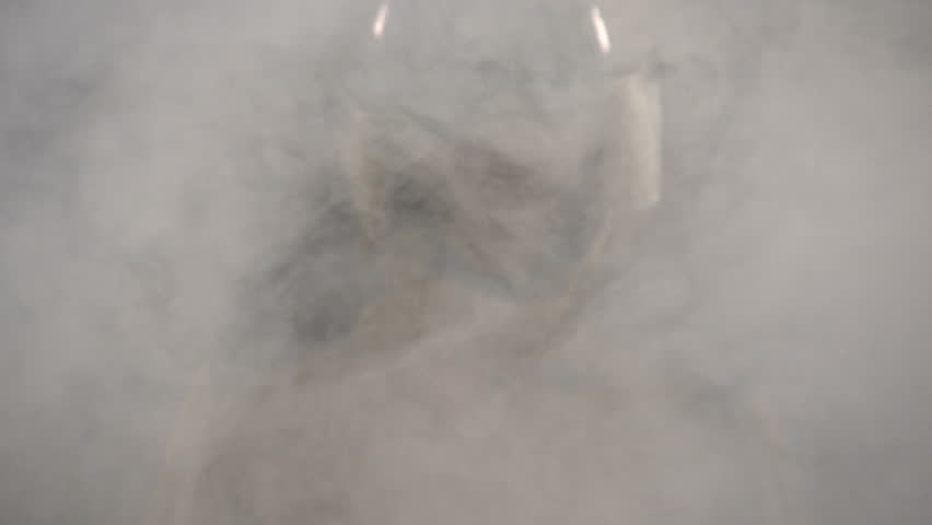 Firefighter walking towards camera through smoke, slow motion