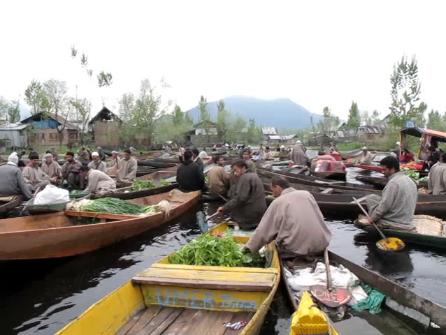 SRINAGAR, INDIA - APRIL 14: Kashmiri men sell their vegetables at a floating market in the early hours before sunrise on April 14, 2012 in Dal Lake, Srinagar, Jammu and Kashmir, India. 