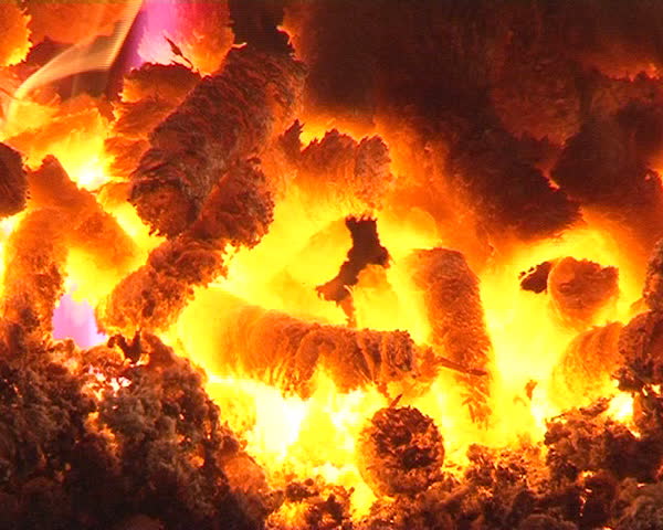 closeup of burn straw pellets in boiler. flames and fire details. ecologic fuel use for home heating.