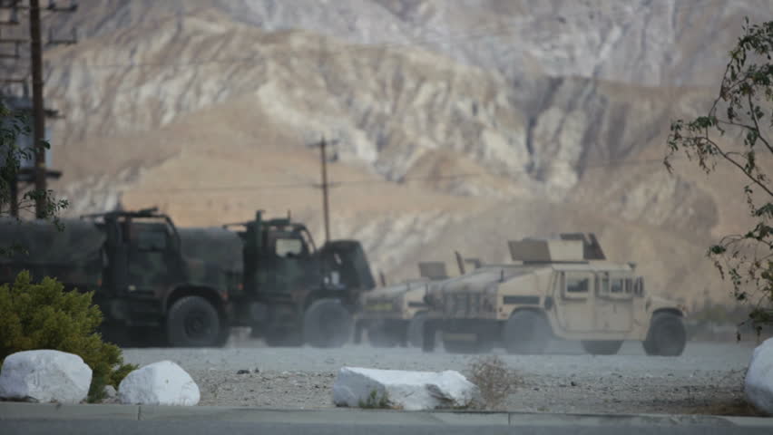 military convoy moving out in desert area