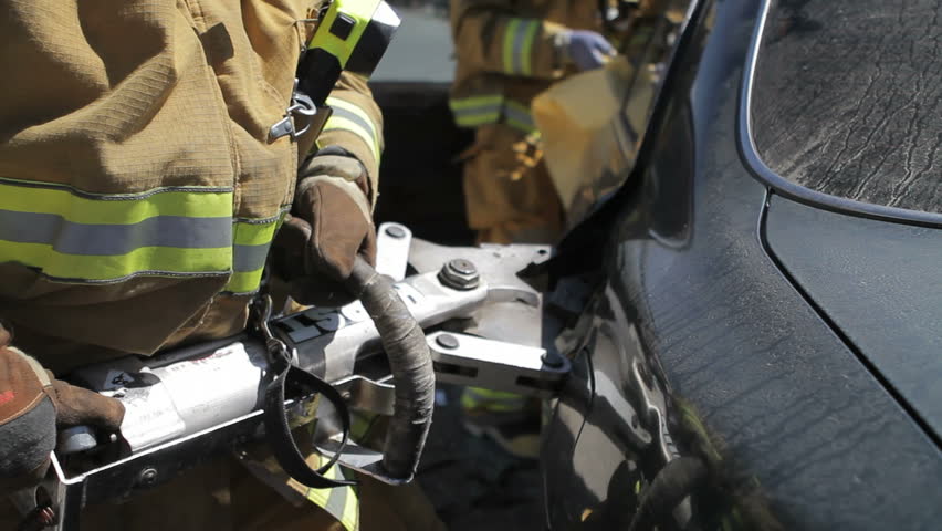 Fireman using the jaws of life at crash site 