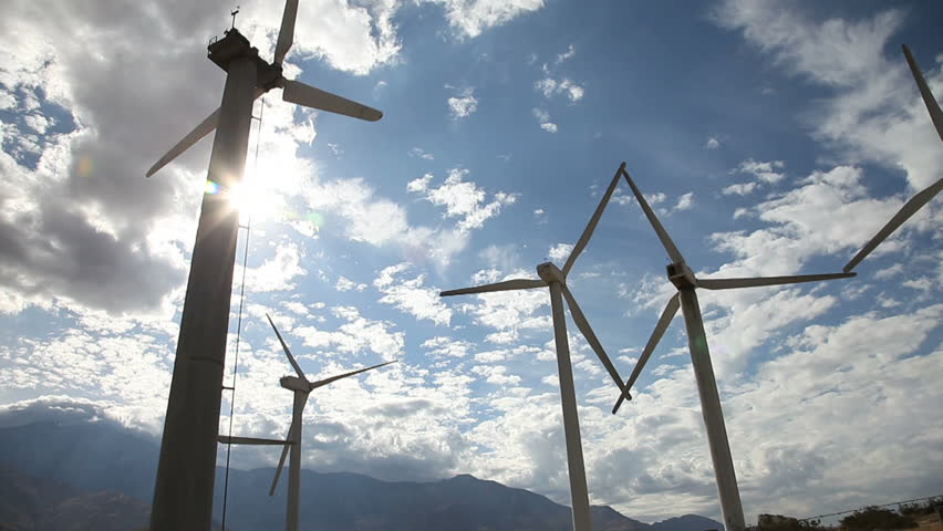 looking up at wind turbines turning