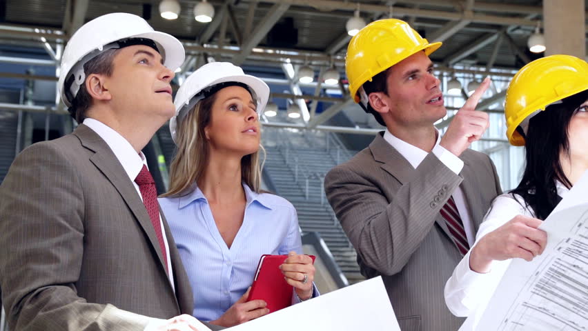 Group of professional engineers and architects in the industrial building.