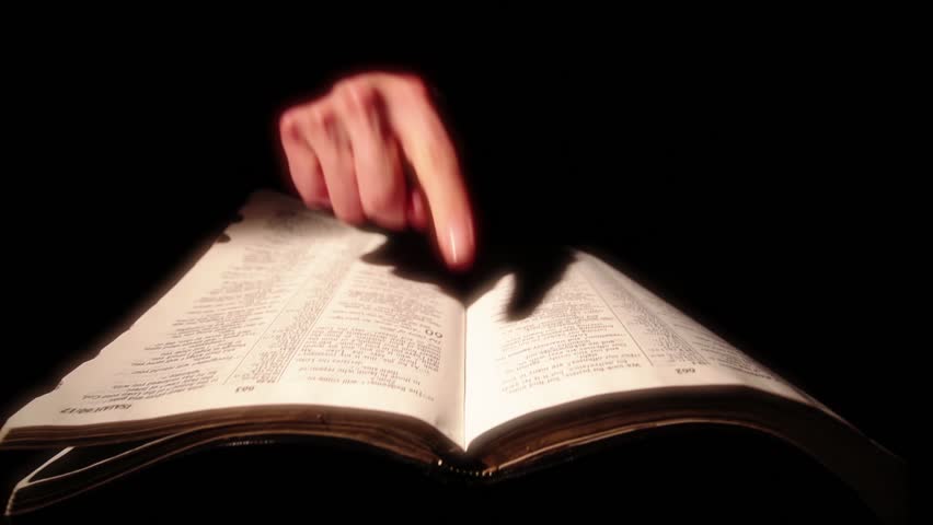 Hands pointing out the scriptures in the Bible