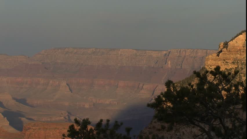 Grand canyon in late afternoon light, junipers in left frame, pan around canyon to south rim of Grand canyon in late afternoon light