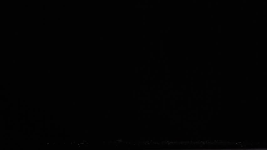 Plastic bottle of water in a super slow motion falling against a black background
