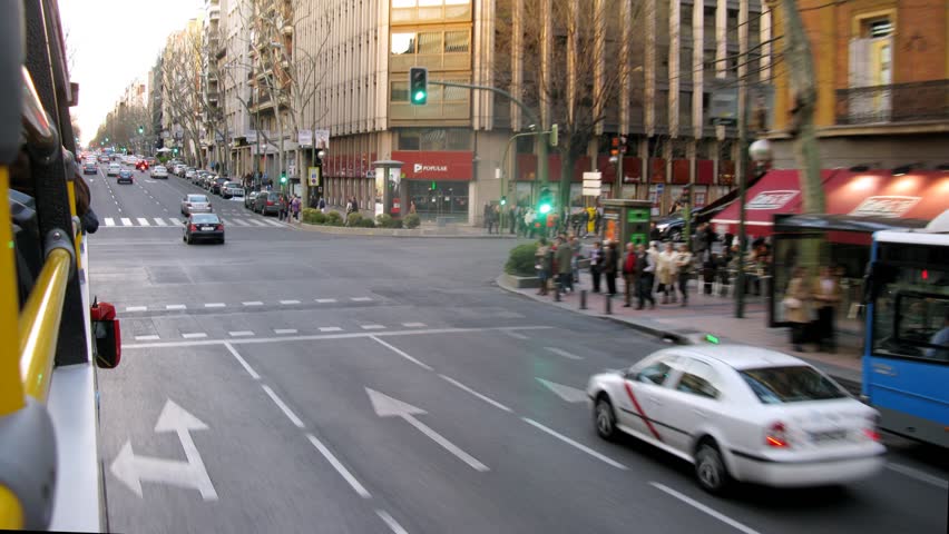 MADRID - MAR 10: (Timelapse View) Bus go near sidewalks on which people walk, on Mar 10, 2012 in Madrid, Spain
