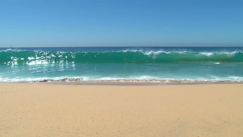 Ocean seascape scenic off Cabo San Lucas, Mexico with large wave crashing on sandy shore.