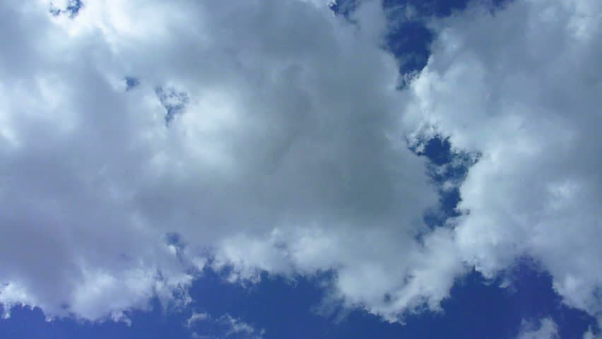 Large storm clouds build and cover the blue sky day time lapse.