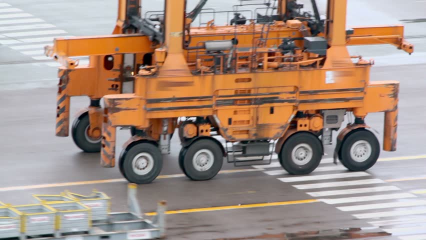 Machine with several wheels rides by asphalt at industrial zone