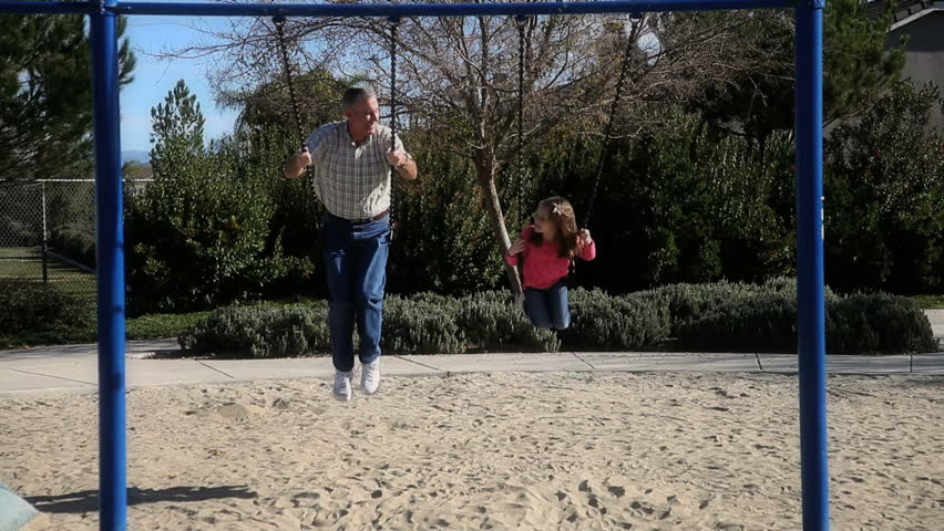 Daddy and daughter on a swingset