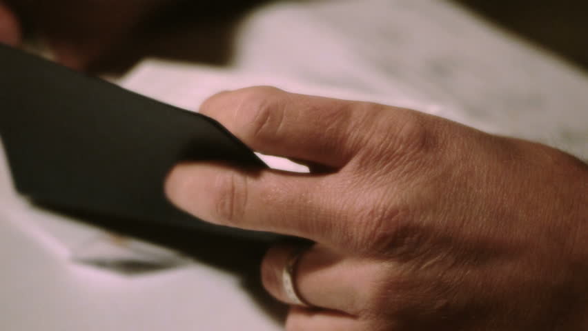close up of a man hand writing in check book register