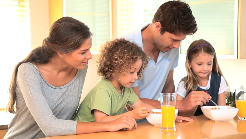Family in the kitchen with bowls of cereal in the morning
