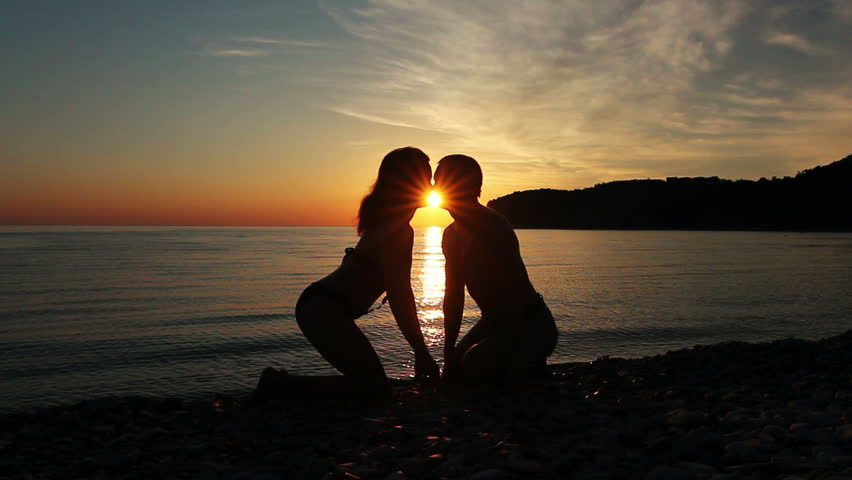 Couple on the shore of the sea, Romantic Couple at Sunset. Two people in love at sunset. Man and woman on the beach