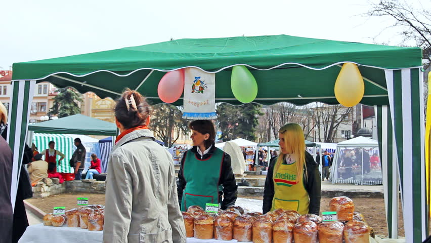 IVANO-FRANKIVSK, UKRAINE - APRIL 12: Nice girls selling paska (Easter bread in Ukraine) at national traditional fair before Easter in city center on April 12, 2012 in Ukraine, Ivano-Frankivsk.