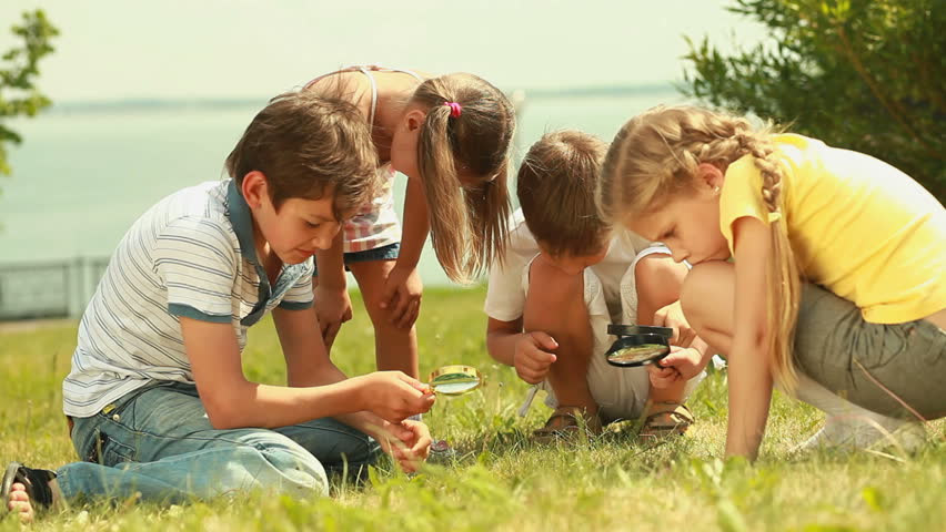 Cute kids with magnifying glasses studying the world around