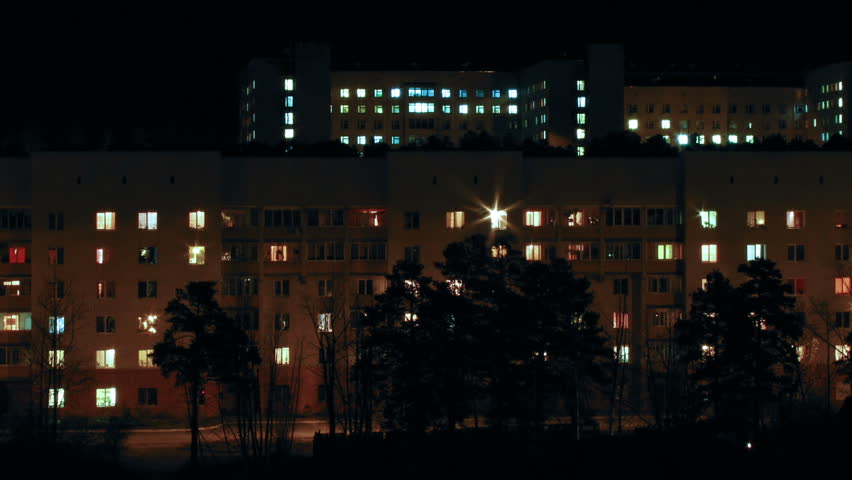Panning timelapse of cityscape with residential windows in night