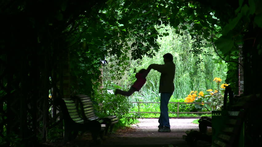 Father Rotatting his Daughter : Silhouette in green arch 