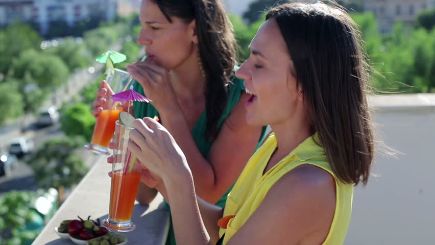 Female friends with exotic drinks on balcony party