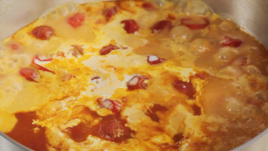 Seasoning creamy tomato soup with basil