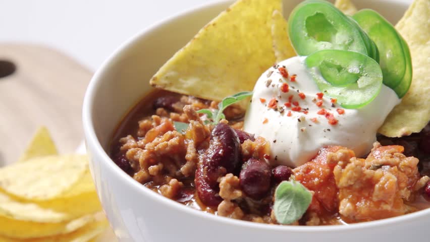 Chilli con carne served with sour cream and tortilla chips