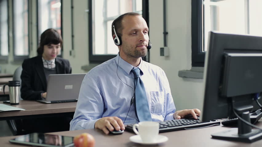 Friendly happy male helpdesk consultant in the office
