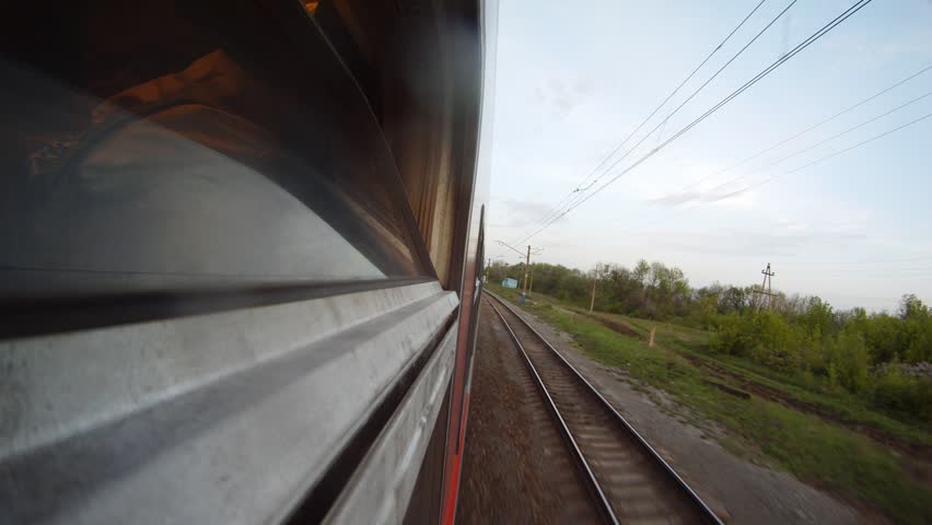 Train goes along forest belt and rural areas in the afternoon, time lapse