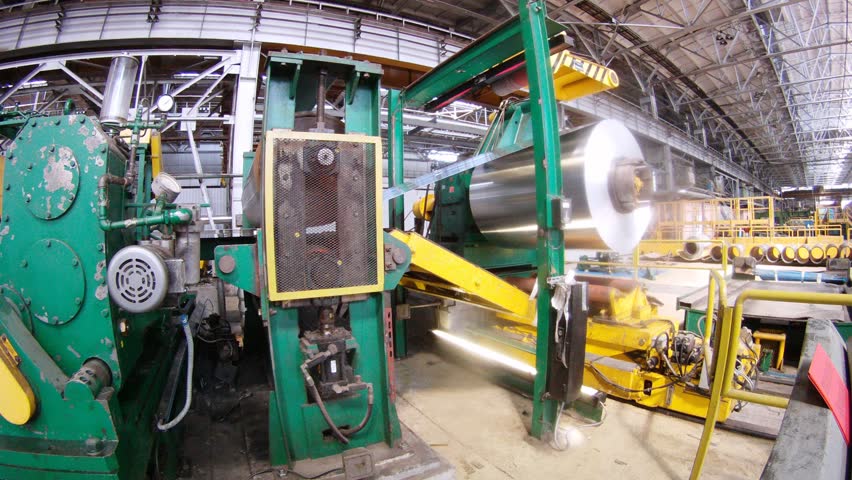 Leaf of aluminum is rewound from one roll on another in production shop, time lapse
