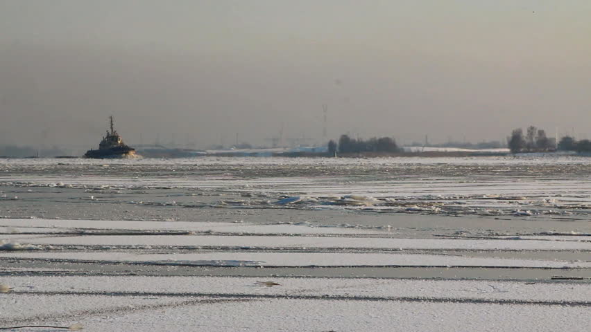 Tug boats moving through Riga port during Winter, in Riga, Latvia.