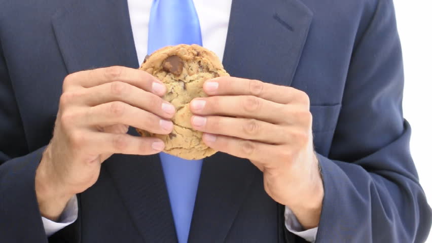 Closeup of businessman crumbling cookie in hands ("Tough cookie to crumble")