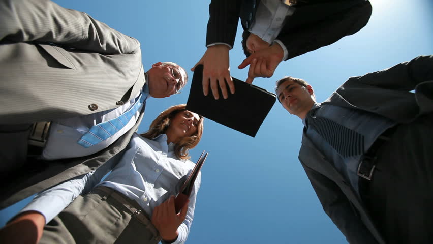Business people viewed from below greeting each other shaking hands and collaborating