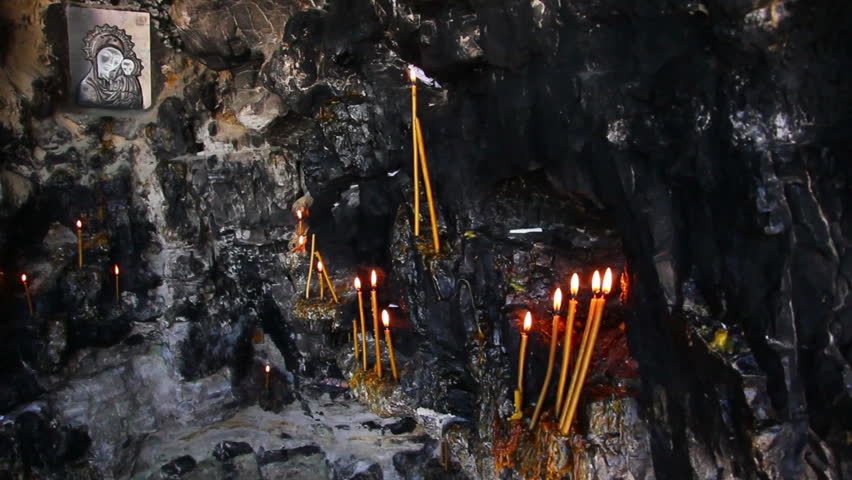 Christian holy place - icon and candles in grotto
