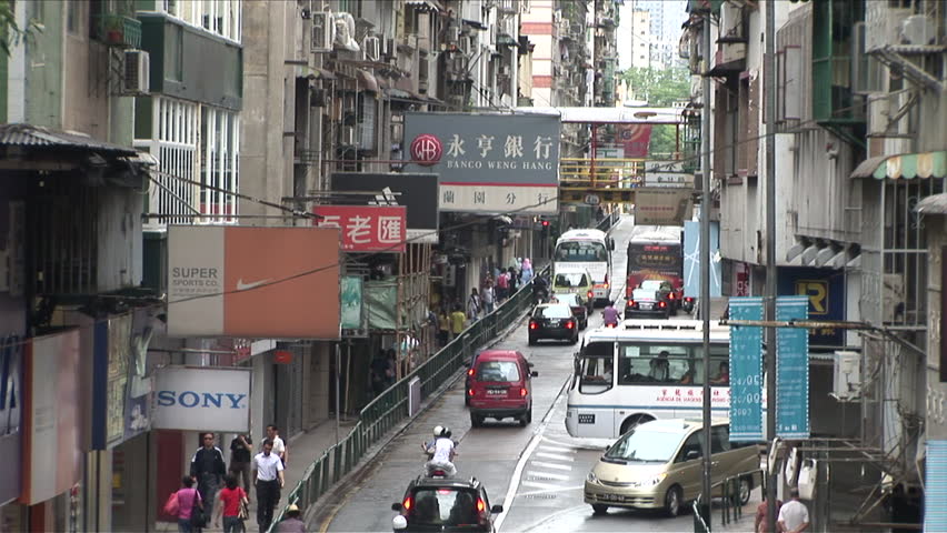 Macau, China - CIRCA March, 2007: A crowded commercial street with cars and pedestrians interacting in harmony